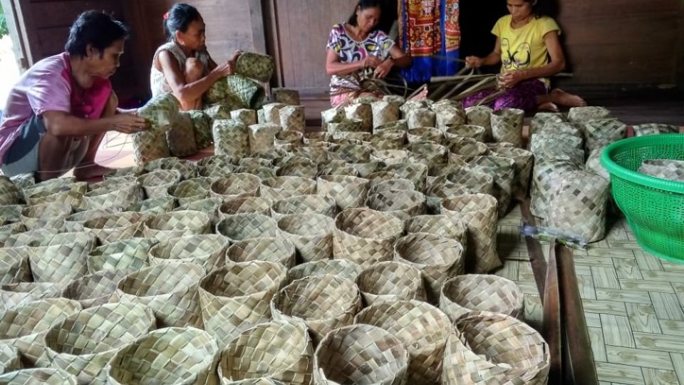 Local women making woven pots for tree saplings