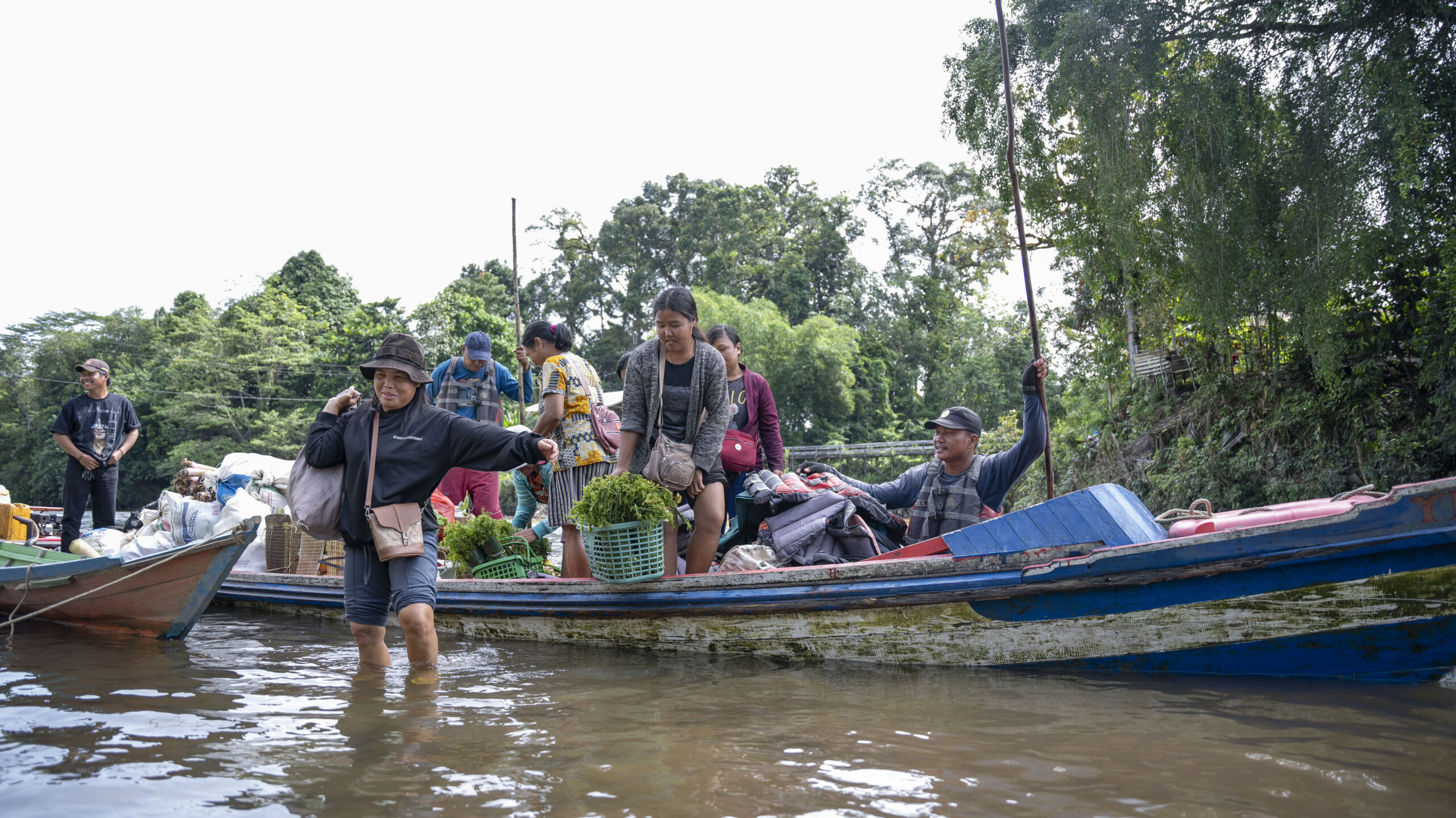 Boat on river in Indonesia filled with villagers taking vegetables to market