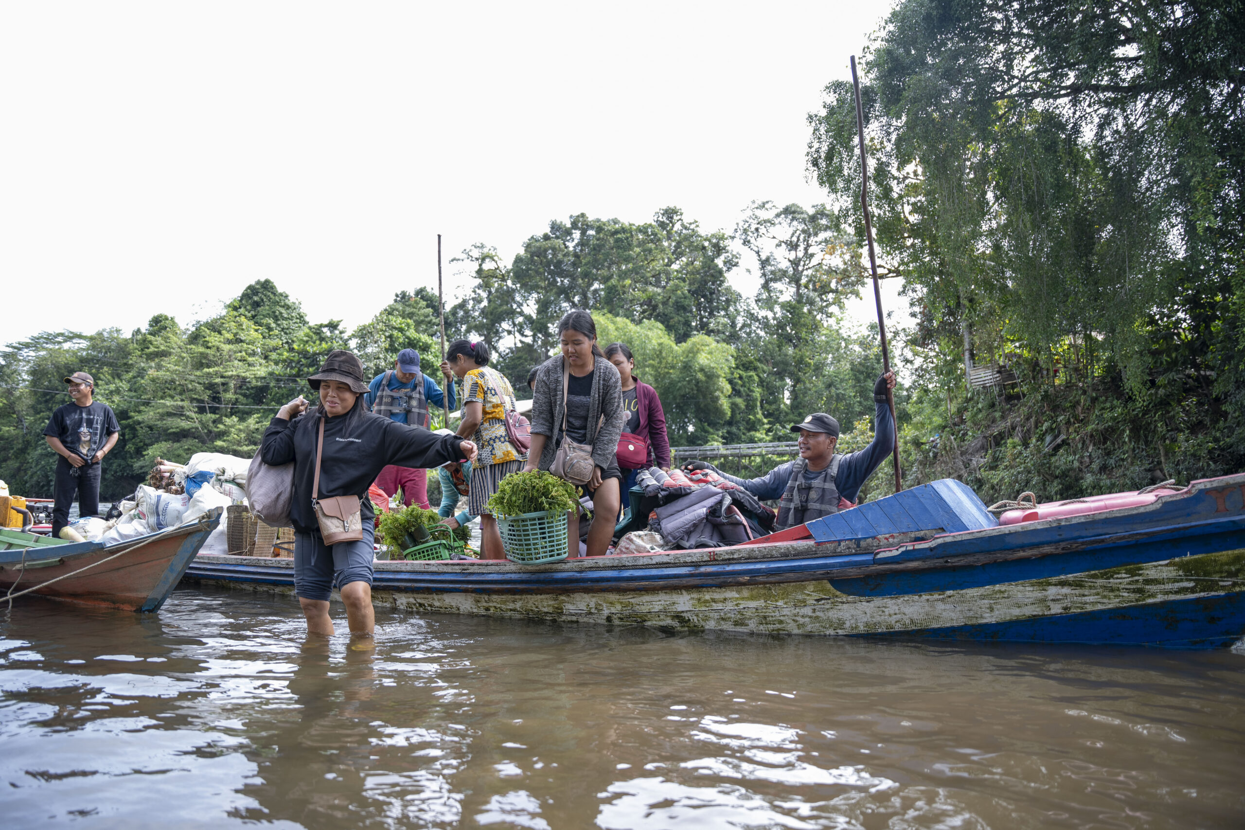 Boat on river in Indonesia filled with villagers taking vegetables to market