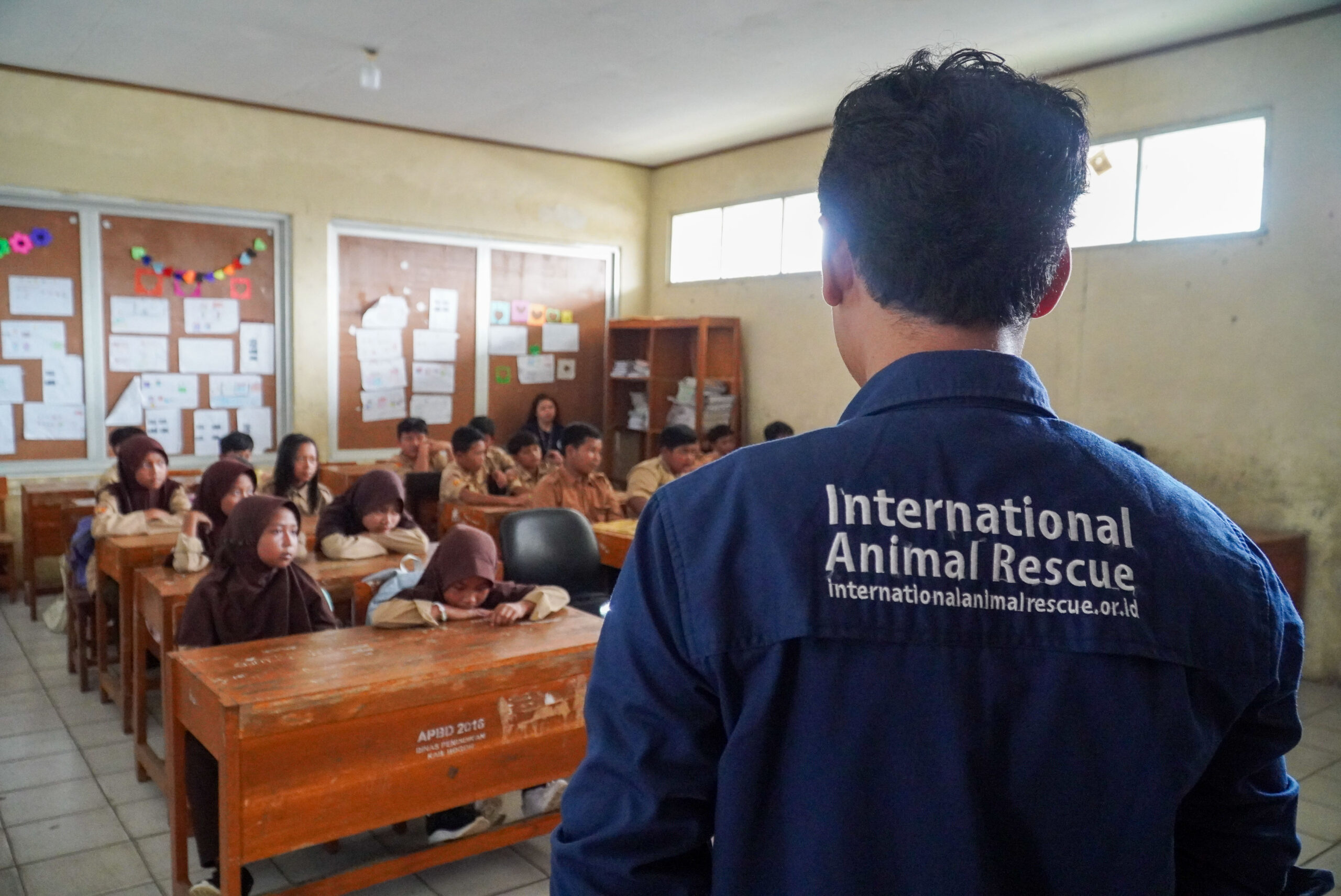 Group of children in classroom being taught about macaques